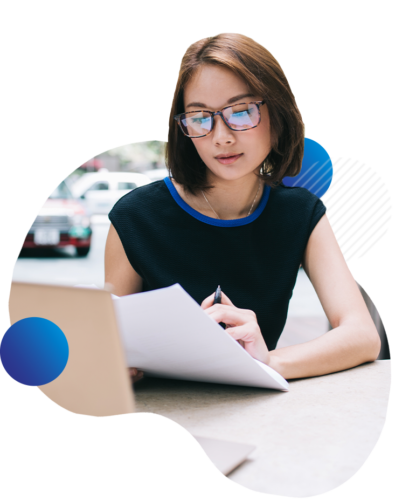 woman reviewing documents in front of laptop