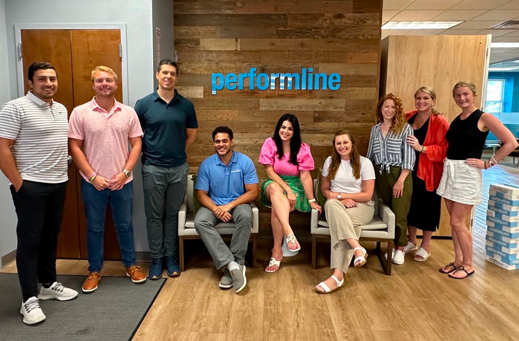 performline employees sitting in front of company logo